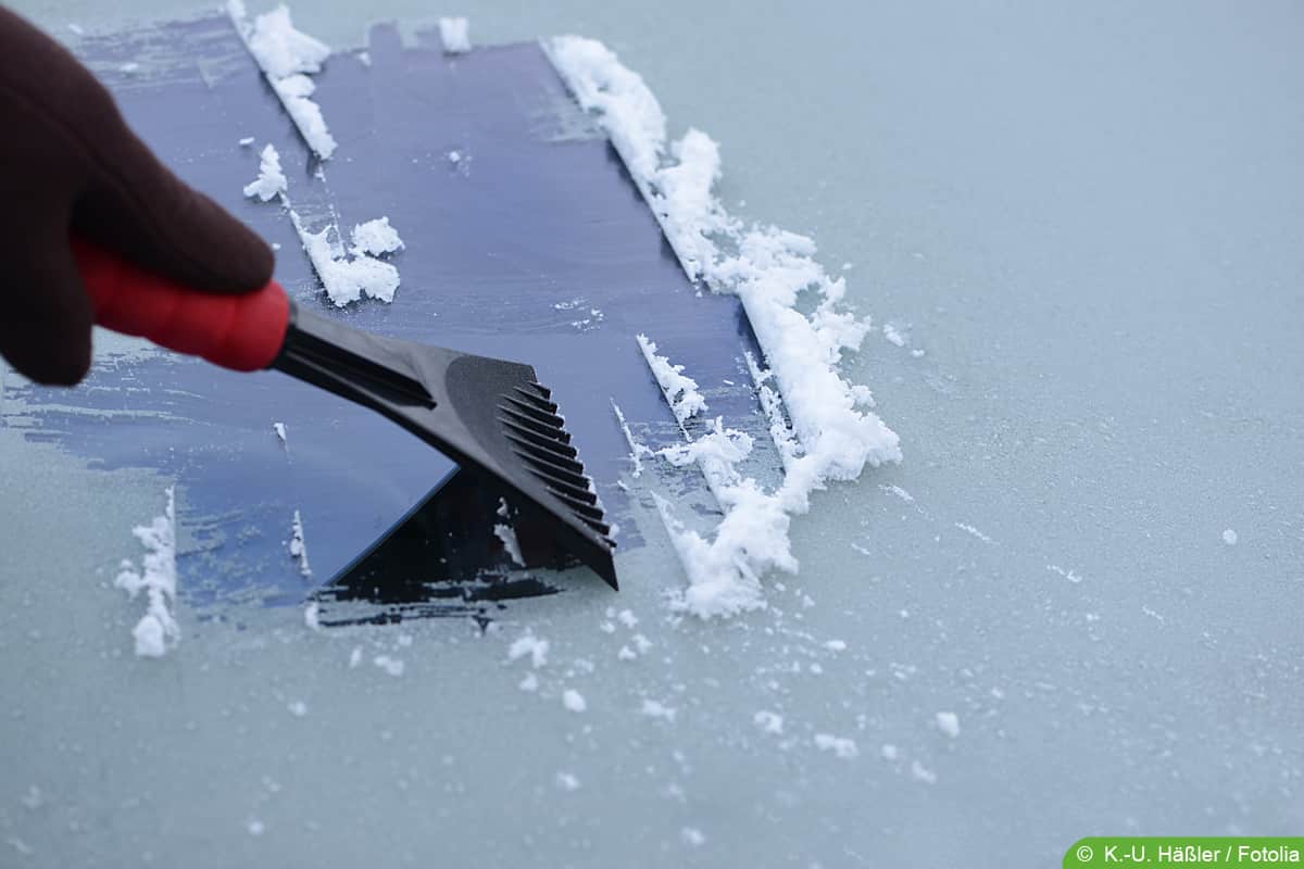 Eiskratzer auf zugefrorener autoscheibe