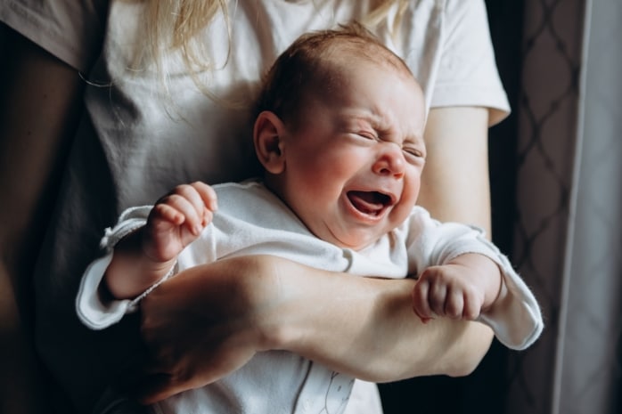 Mutter hält schreiendes Baby