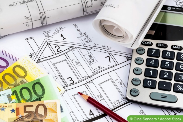 Bauvoranfrage Kosten - Hausplan mit Taschenrechner, Bleistift und Geldscheinen