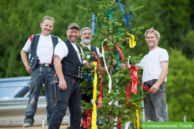 Richtbaum schmücken - Handwerker mit Baum beim Richtfest